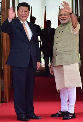 Chinese President Xi Jinping and Modi waves to the crowds during the former's visit to India earlier this year.