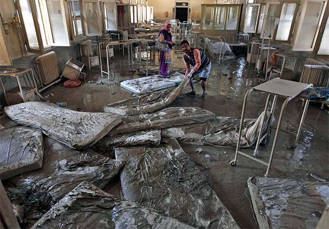Muddied mattresses being removed from a hospital in Srinagar.