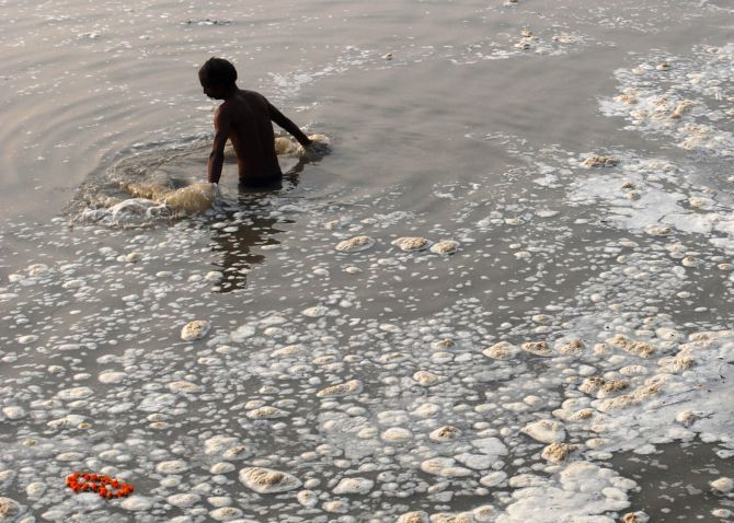 A devotee takes a dip in the Sangam, the confluence of the Ganga, Yamuna and Saraswati in Allahabad. Photograph: Jitendra Prakash/Reuters
