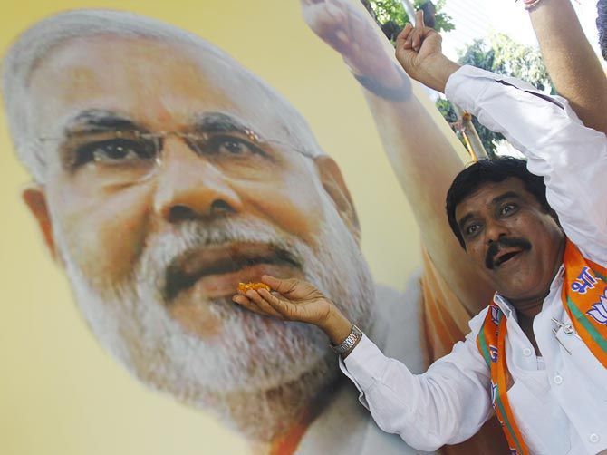A BJP supporter feeds sweets to a Modi poster at the party’s office in Mumbai. Photograph: Hitesh Harisinghani/Rediff.com