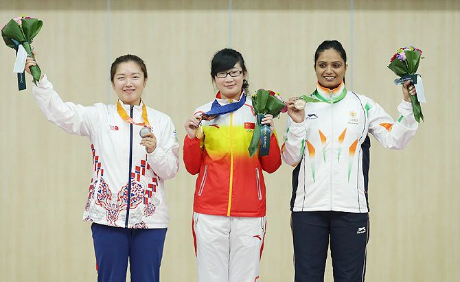 Gold Medalist Mengyuan Zhang of China (centre), Silver Medalist Jung Jee-Hae of South Korea (left), and Bronze Medalist Shweta Chaudhry of India (right) celebrate on the podium after winning their medals in the 10m Air Pistol Women's event