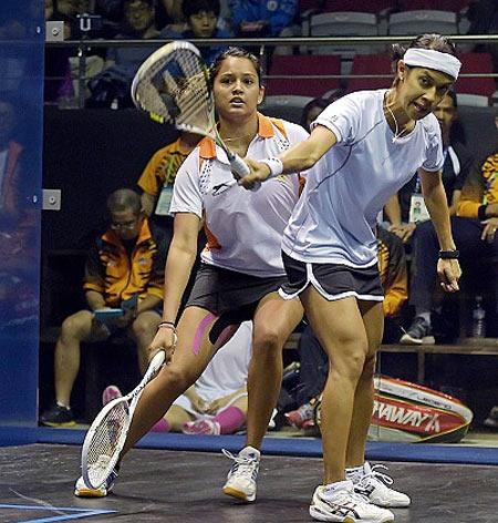 Malaysia's David Nicol Ann (R) returns a shot against India's Pallikal Dipika Redecca (L)