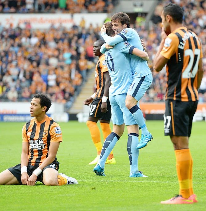 Edin Dzeko of Manchester City celebrates with team-mate David Silva after scoring his team's second goal during the Barclays Premier League match against Hull City