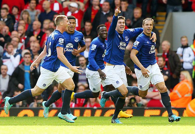 Phil Jagielka (R) of Everton celebrates with teammates after scoring a late goal to level the scores at 1-1 