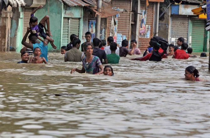 Locals wade through a waterlogged road in Kalighat, Kolkata