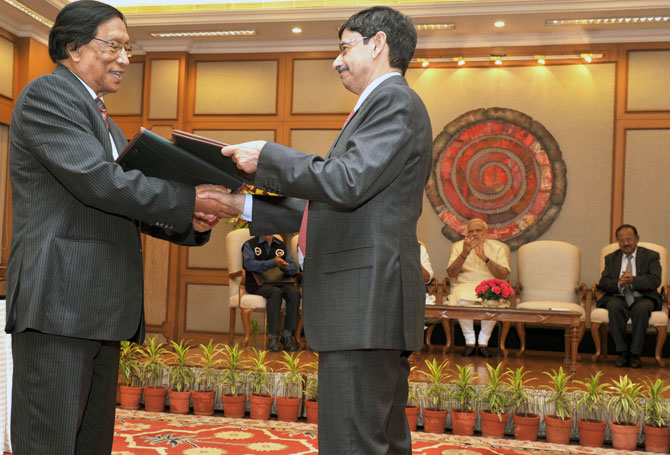 Thuingaleng Muivah, left, and R N Ravi, the Government of India's Special Interlocutor for the Naga talks, exchange copies of the agreement the NSCN-IM reached with the government, August 3, 2015. Photograph: Press Information Bureau