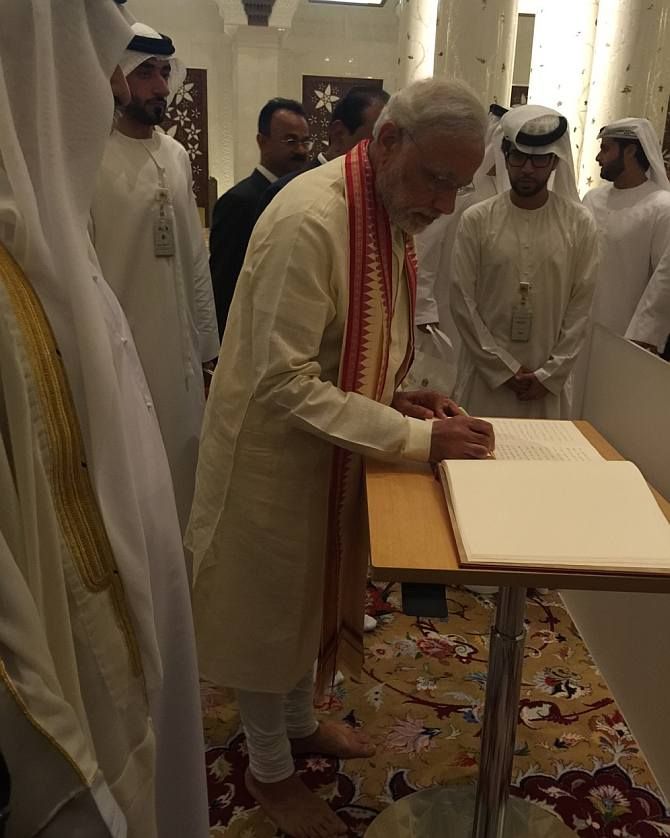 Indian Prime Minister Narendra Modi writing his comments in the visitors' book at the Sheikh Zayed Grand Mosque.