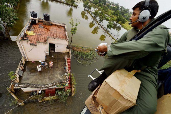 A Coast Guard helicopter drops relief material to residents stranded on a rooftop in Chennai. Photograph: R Senthil Kumar/PTI Photo