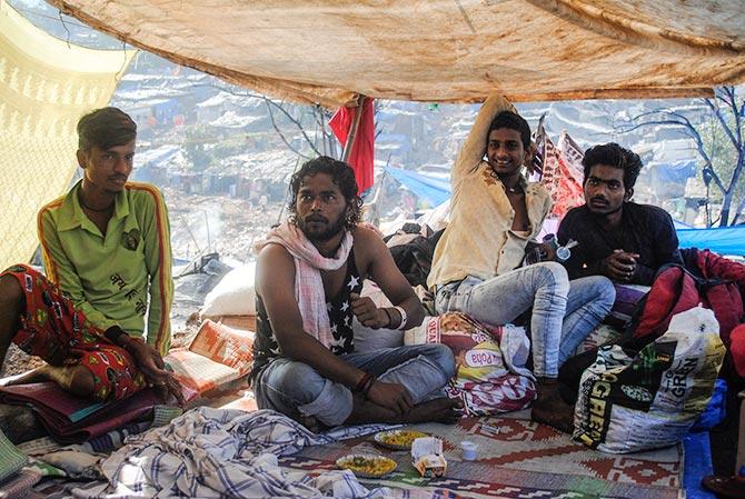 Vilas Kamble and his friends eat their breakfast, puffed rice, provided by several NGOs who are working among the people of Damu Nagar and providing them succour