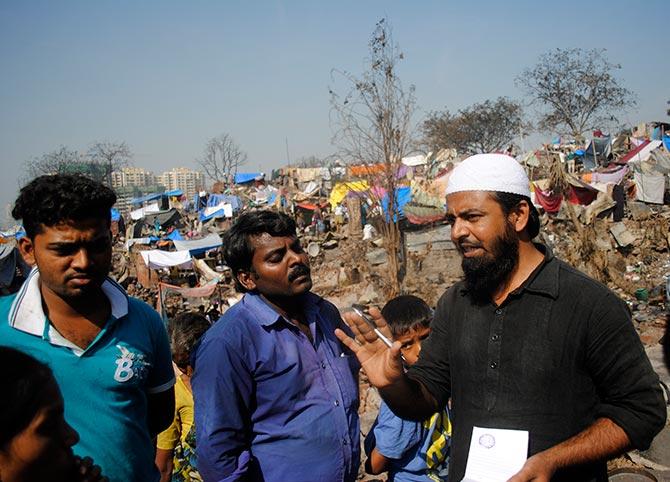 Zamir Mujawar from a local madarsa issuing small chits of paper to the victims