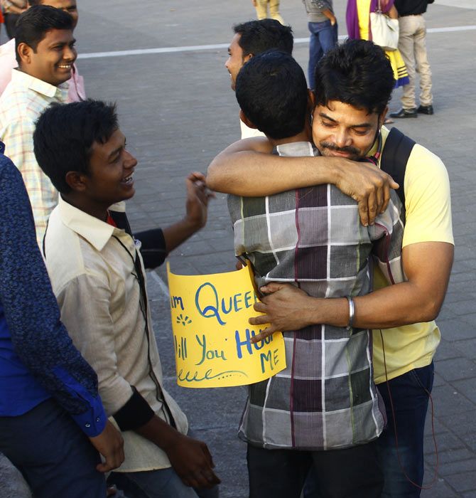 A volunteer of the 'Queer Hugs' campaign gets a warm hug from a passerby