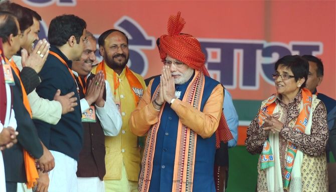 Narendra Modi greets BJP leaders during a Delhi assembly election campaign rally
