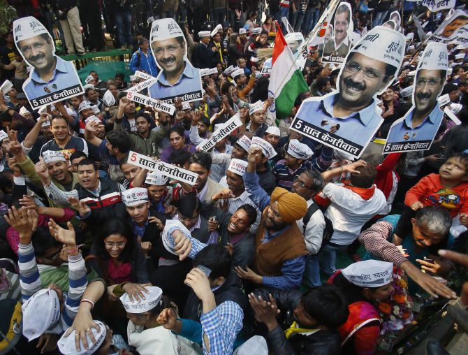 Aam Aadmi Party supporters with portraits of AAP leader Arvind Kejriwal, during celebrations outside the party office in New Delhi. Photograph: Anindito Mukherjee/Reuters