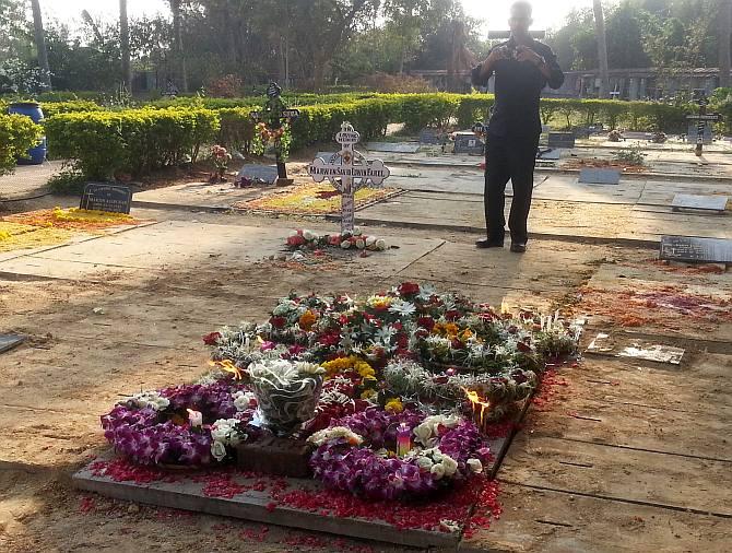 Kevin clicks a photograph of Russel Rebello's grave