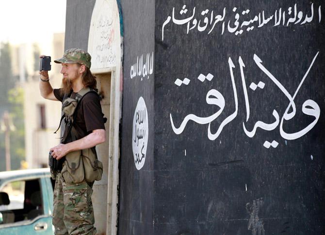 A Daesh terrorist films a Daesh military parade in Raqqa, Syria. Photograph: Reuters