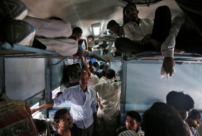 Passengers sit inside a crowded stationary train at a railway station in New Delhi.