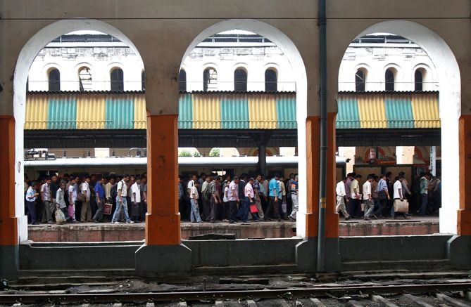 Commuters walk on a crowded platform at a railway station in Kolkata. 