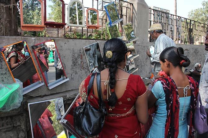 Women at a pavement mirror shop. Ahmedabad