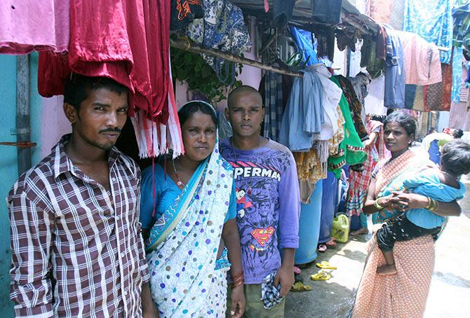 Sharda with Balaji (right) and Arun (left), outside their house