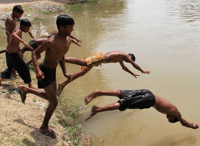 Children cool off in a canal in Bhatinda, Punjab. Photograph: PTI. 