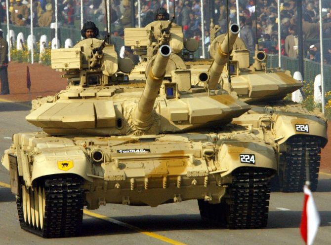 Indian soldiers sit atop T-90 tanks.