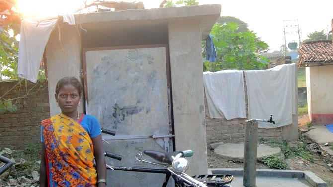 A woman stands outside her toilet door