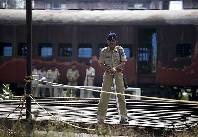 A policeman stands guard near the train carriage that was set on fire in 2002, during the commemoration of the 12th anniversary of the Godhra riots at Godhra in Gujarat, February 27, 2014. The riots were some of the country's worst religious riots since Independence, killing some 2,500 people, mainly Muslims.
