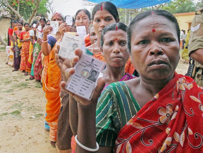 Women show their voter cards at a polling booth during the assembly election at Bandhlodanga in Birbhum, Bengal. Photograph: PTI