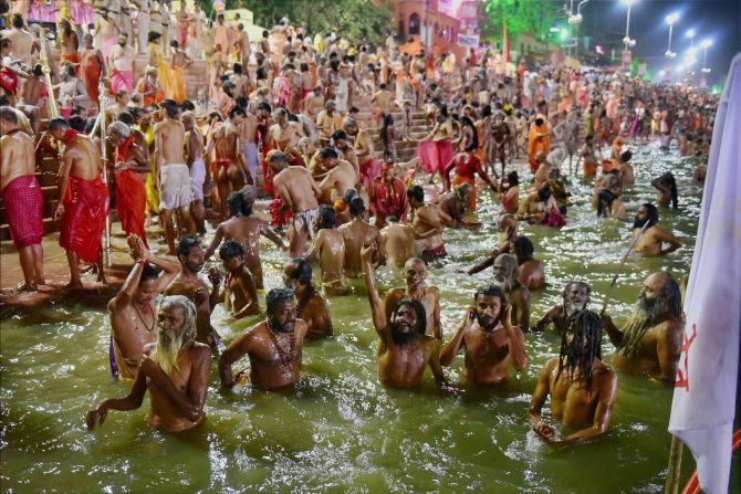 IMAGE: Naga sadhus take a dip in the Shipra river on the first Shahi Snan during the Simhastha Mahakumbh in Ujjain. Photograph: PTI 