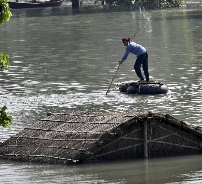 A man uses a boat to escape a water-logged village in Bihar. Photograph: PTI
