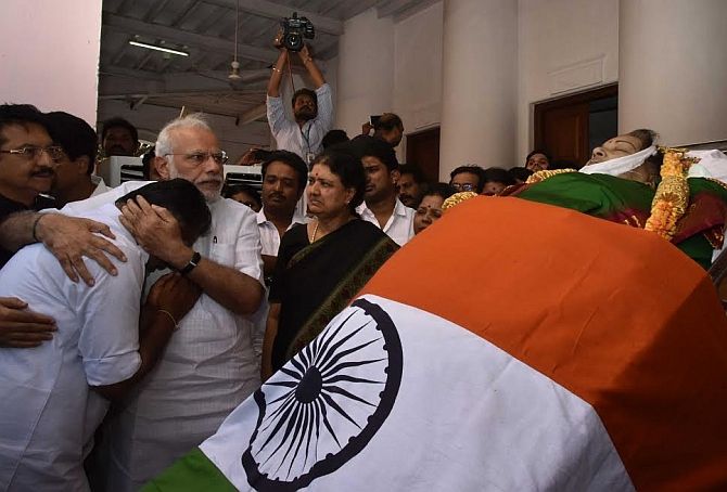 Prime Minister Narendra Modi consoles a distraught O Panneerselvam as V K Sasikala looks on