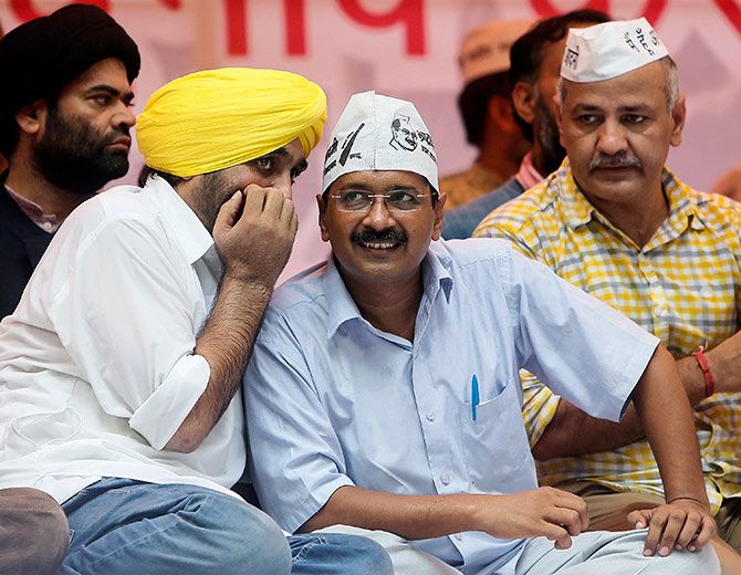 Delhi's chief minister and Aam Aadmi Party (AAP) chief Arvind Kejriwal listens to his party leader and MP Bhagwant Mann during a rally in 2014