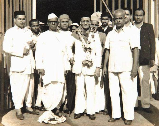 Savarkar, centre, with garland