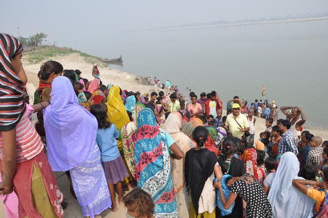 Team members speaking to villagers on the banks of the river