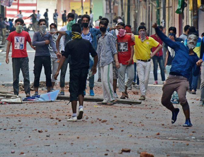 Young Kashmiris pelt stones at the security forces in Srinagar days after Burhan Wani's death