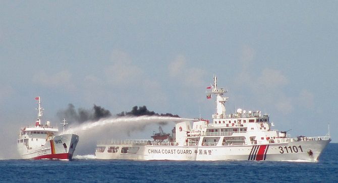 Chinese coast guard ship (right) uses a water cannon on a Vietnamese naval vessel near the disputed Paracel Islands in the South China Sea