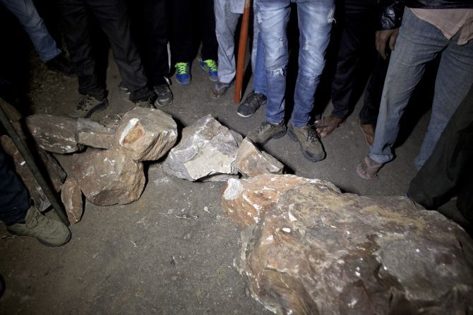 Stones placed on the road to halt trucks that could be carrying cows. The gau rakshaks stand by with weapons. Photograph: Allison Joyce/Getty Images