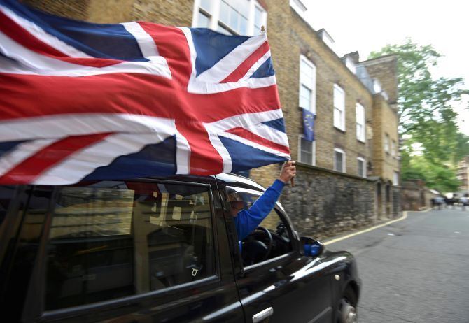 A taxi driver holds a Union flag in London