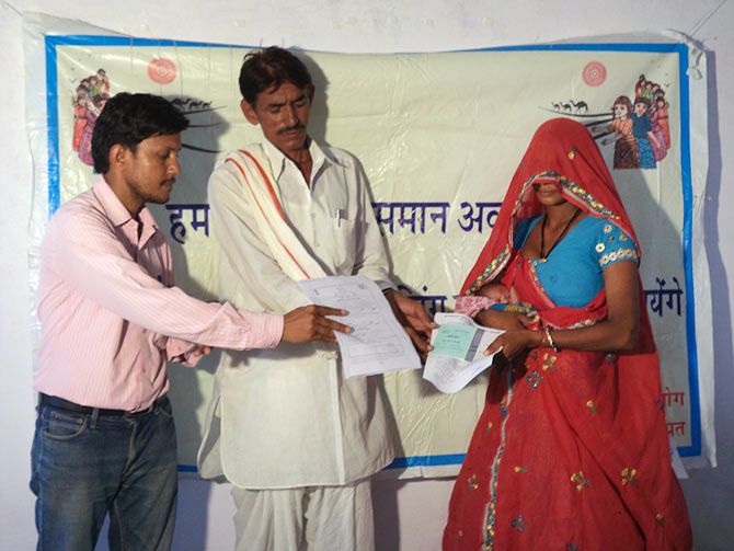 A bank account passbook, in the name of the girl child, and the birth certificate is handed over to the mother in Dausa, Rajasthan.