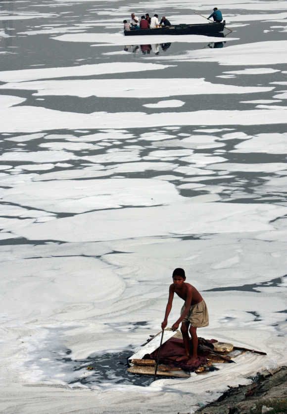 A boy looks for recyclable items in the polluted waters of the Yamuna river in New Delhi.