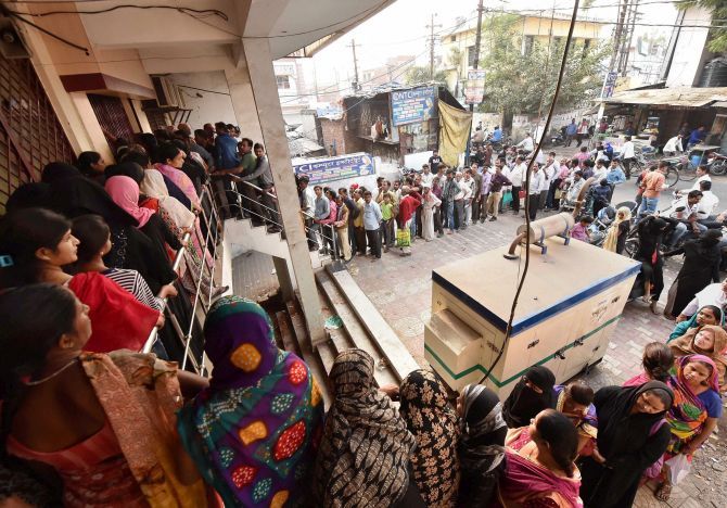 People queue up outside a bank to exchange their old Rs 1000 and 500 notes in Lucknow