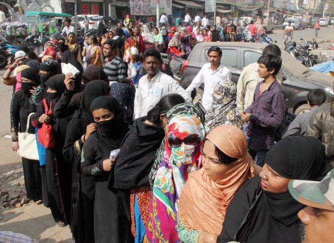 Women queue-up outside a bank to exchange their old notes