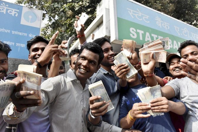 PATNA: People show money withdrawn from an ATM. Photograph: PTI Photo