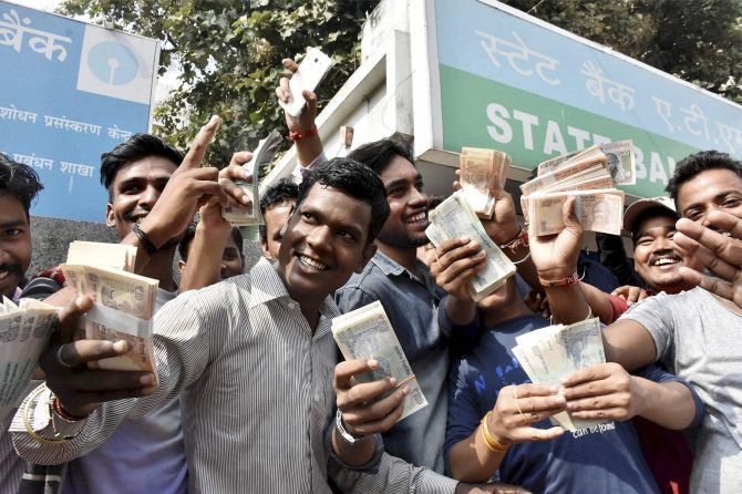 Cheerful Indians with money withdrawn from an ATM in Patna, November 13, 2016. Photograph: PTI Photo