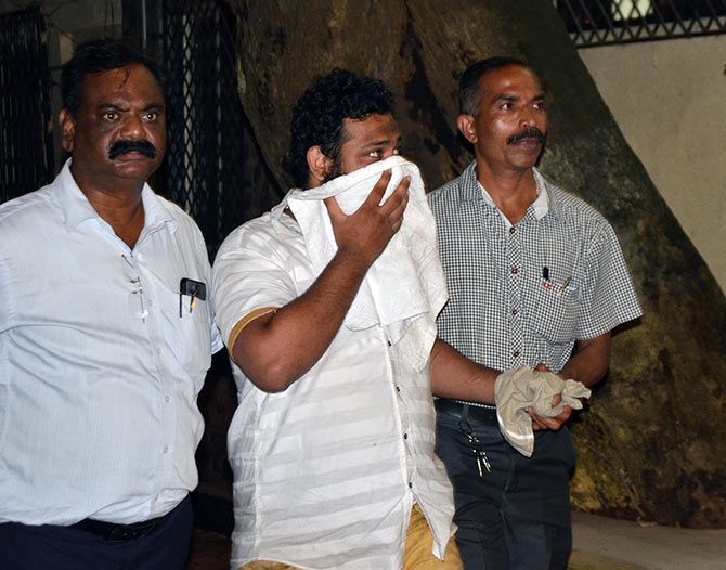 One of the 70 accused in police custody being taken for questioning at the Thane Crime Branch's Unit 1