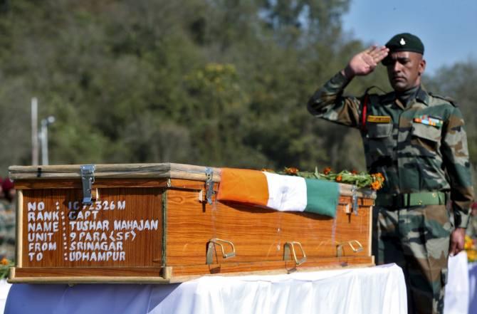 An Indian Army officer salutes at the coffin containing the body of Tushar Mahajan, an army officer who was killed in a gunbattle, in Udhampur, north of Jammu. 