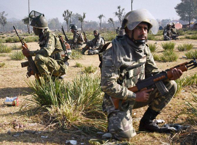 Security forces outside a building occupied by terrorists in Pampore