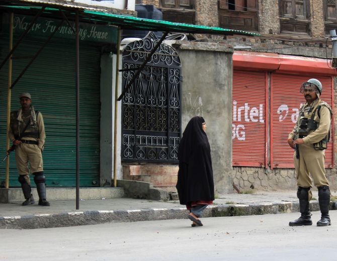 A woman and security personnel on a deserted Srinagar street on the 63rd day of curfew in the Kashmir valley. Photograph: Umar Ganie