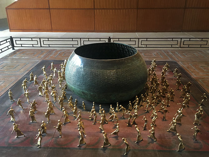 Installation depicting Buddha's begging bowl surrounded by monks