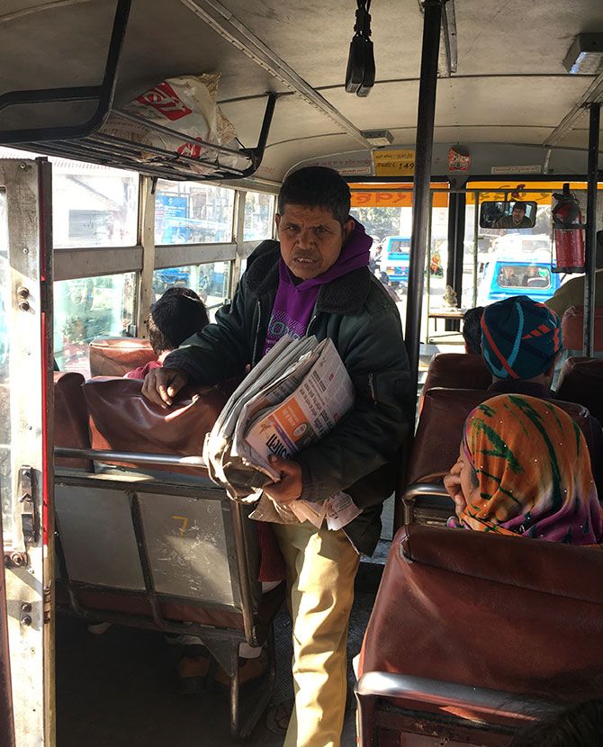 A newspaper vendor on the bus